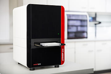 qTOWER3 auto qPCR instrument holding a PCR plate on an extended tray