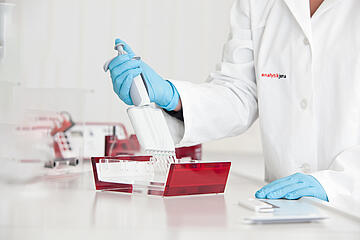 A scientist loading samples into the wells of a Biometra agarose electrophoresis tray.
