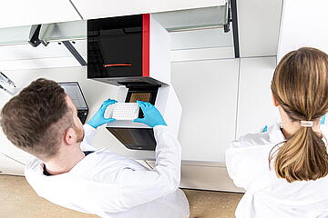 Two persons in lab working with qTOWER iris
