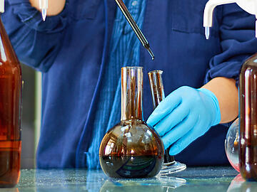 Laboratory flask with crude oil. Lab test  petroleum in the background.
