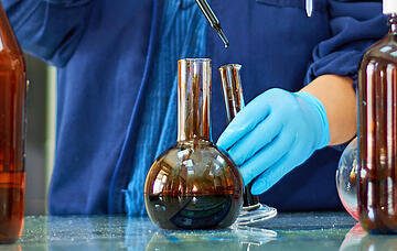 Laboratory flask with crude oil. Lab test  petroleum in the background.