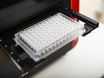 close-up view of a qTOWER3 auto qPCR instrument ejecting a 96-well PCR plate 